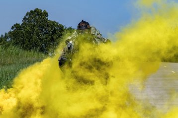 Army Sgt. Kurt Van De Graaff marches through a cloud of smoke as part of a ruck march event during the 2019 Army National Guard Best Warrior Competition at Camp Gruber in Braggs, Okla., July 18, 2019.