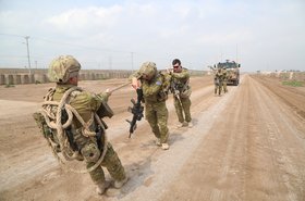 Australian soldiers with Task Group Taji pull a Bushmaster Protected Mobility Vehicle