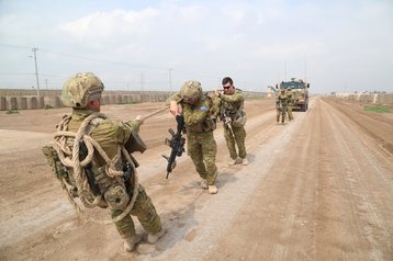 Australian soldiers with Task Group Taji pull a Bushmaster Protected Mobility Vehicle