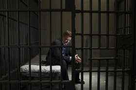 Businessman in a prison cell