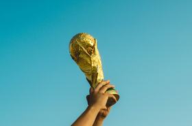 Footballer holding aloft the World Cup