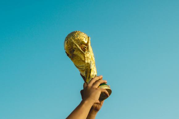 Footballer holding aloft the World Cup