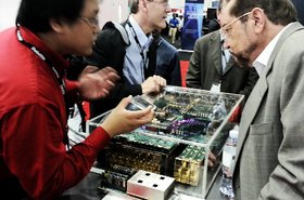 Fujitsu engineer James Li (left) shows an Oracle OpenWorld 2012 attendee the Fujitsu prototype server built on its latest Sparc 64-X CPUs and one of the chips