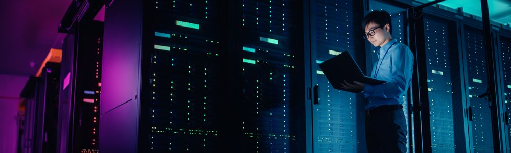 IT technician running a maintenance programme in front of a server rack