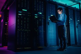 IT technician running a maintenance programme in front of a server rack