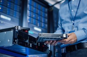 Engineer holding new HDD hard drive to Install into server rack