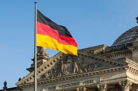 The German flag fluttering front of Reichstag building. Berlin, Germany