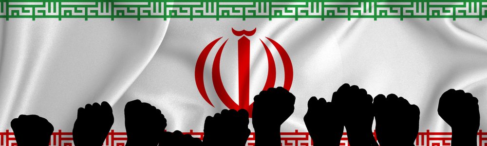 Silhouette of raised arms and clenched fists on the background of the flag of Iran.