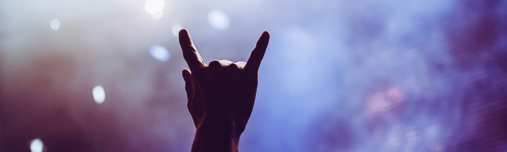 Horns raised up by a metalhead in the crowd in front of stage