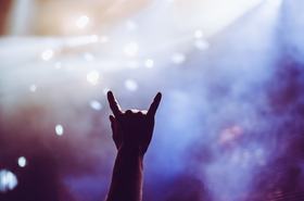 Horns raised up by a metalhead in the crowd in front of stage
