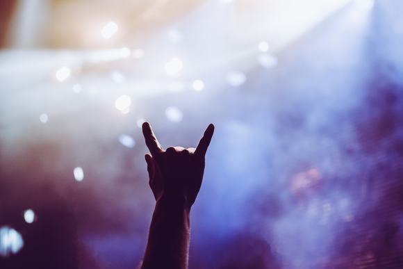 Horns raised up by a metalhead in the crowd in front of stage