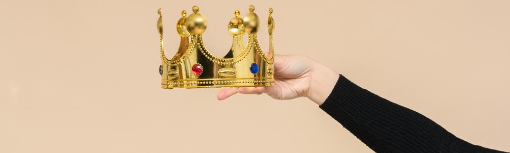 A pair of hands handing over a crown