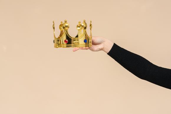A pair of hands handing over a crown