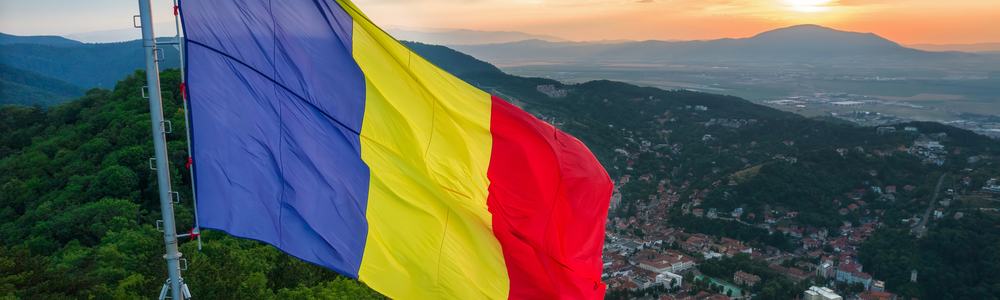 Romanian flag on the top of the hill in Brasov at sunset