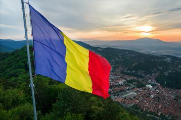 Romanian flag on the top of the hill in Brasov at sunset