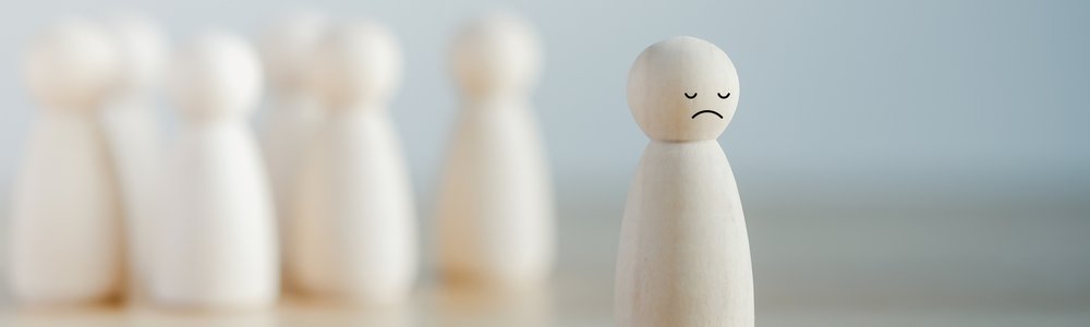 Bullying concept of wooden figures singling out one sad one