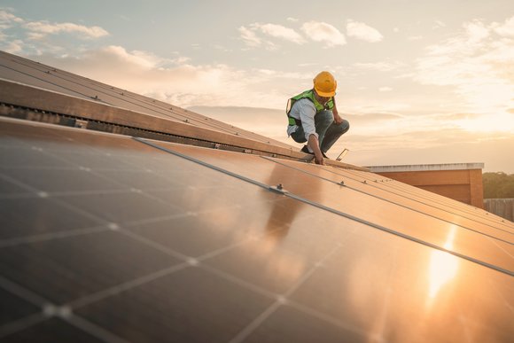 Ingeniero de servicio revisando la célula solar en el techo para el mantenimiento si hay una pieza dañada. Ingeniero trabajador instalar panel solar. Concepto de energía limpia. - Fotografía de stock