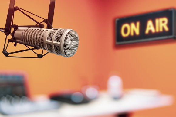 Professional podcasting studio with a microphone and on air sign