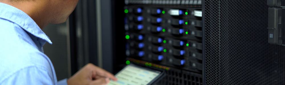 IT technician inspects and manages a server rack in a data center
