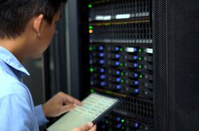 IT technician inspects and manages a server rack in a data center