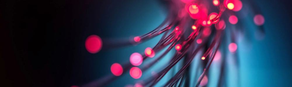 Fiber optic cables with vibrant red and blue lights illuminate a dark background