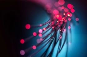 Fiber optic cables with vibrant red and blue lights illuminate a dark background
