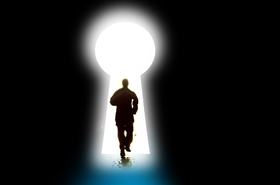 Silhouette of a man running through a keyhole