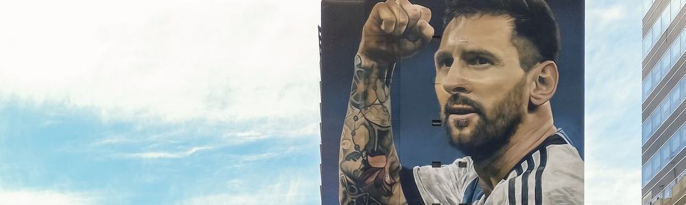 Street art mural by Martin Ron featuring Lionel Messi famous football player in national team jersey