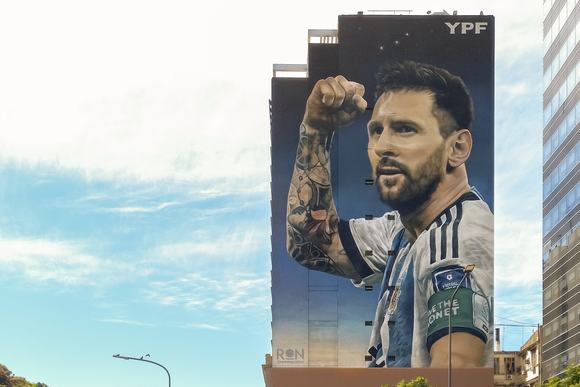 Street art mural by Martin Ron featuring Lionel Messi famous football player in national team jersey