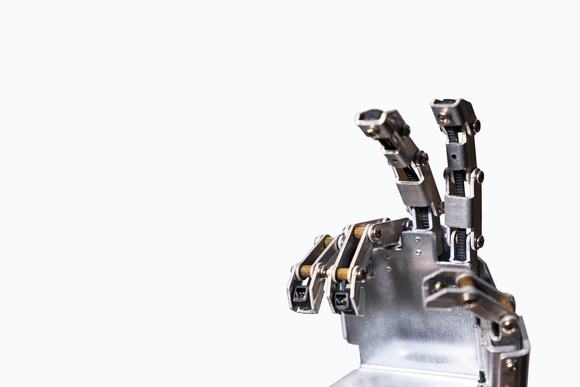 A metal robotic hand making a V sign