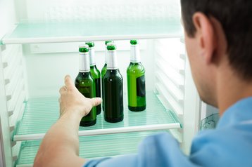 Man removing label-free beer bottle from refrigerator