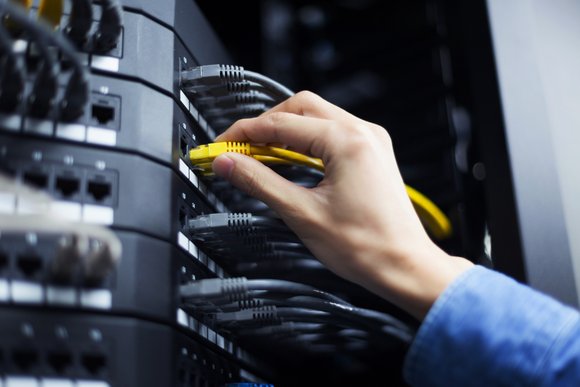 Hand with network cable in a data center