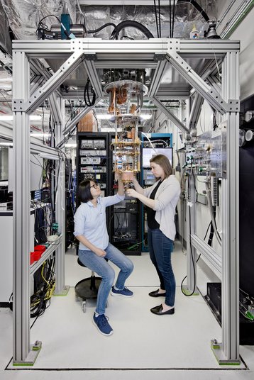 IBM Quantum Computing Scientists Hanhee Paik (left) and Sarah Sheldon (right) examine the hardware inside an open dilution fridge at the IBM Q Lab at IBM's T. J. Watson Research Center in Yorktown, NY.