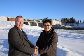 Erik Svensson and Canaan CEO N.G. Zhang in front of a hydro power plant on the Lulea river