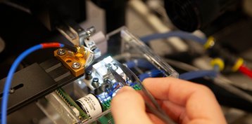Close up of a NLM-supported chip being put on a probe station