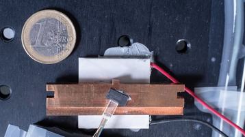Loughborough University's ‘rainbow’ microcomb chip. €1 coin for reference