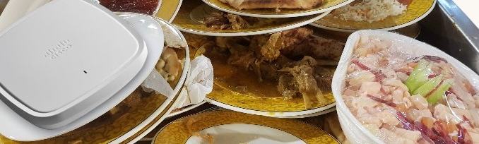 Cisco Catalyst 9130AX Series placed on a pile of dirty plates from a buffet