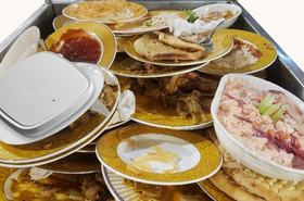Cisco Catalyst 9130AX Series placed on a pile of dirty plates from a buffet