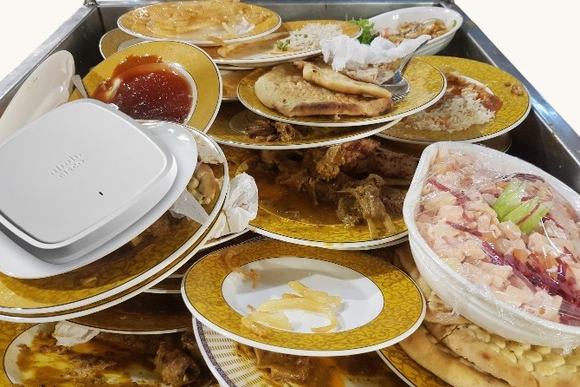 Cisco Catalyst 9130AX Series placed on a pile of dirty plates from a buffet